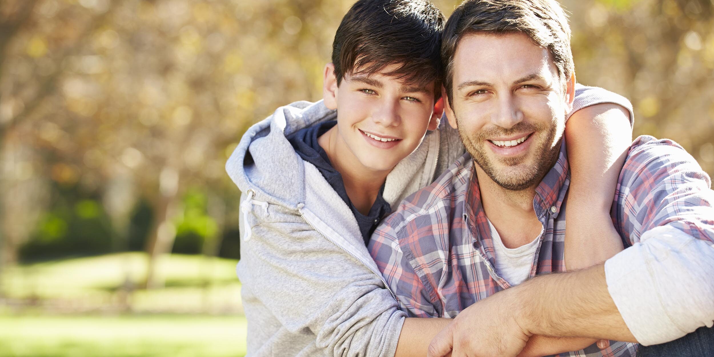 Happy dad smiling after son's tooth extraction appointment